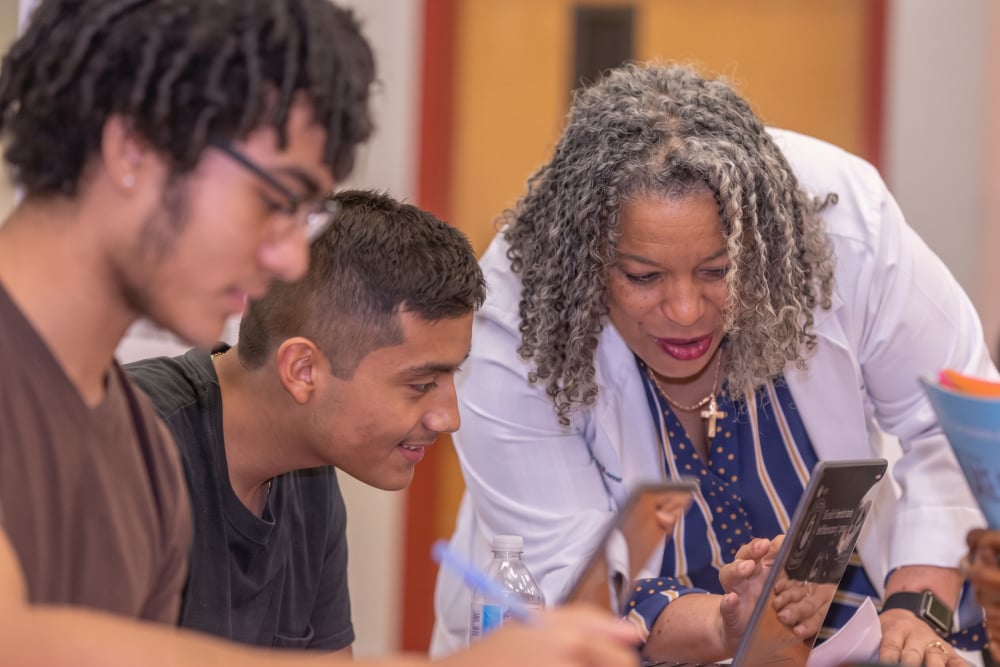 TLJMS featuring the educator working with the students on a laptop